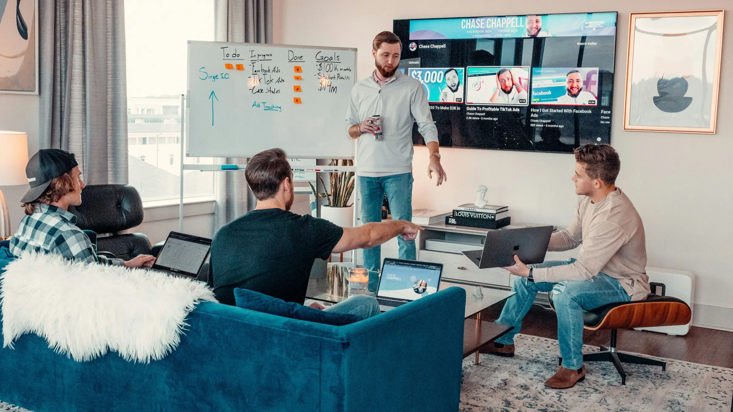 Software team discussing a project around a whiteboard and large screen