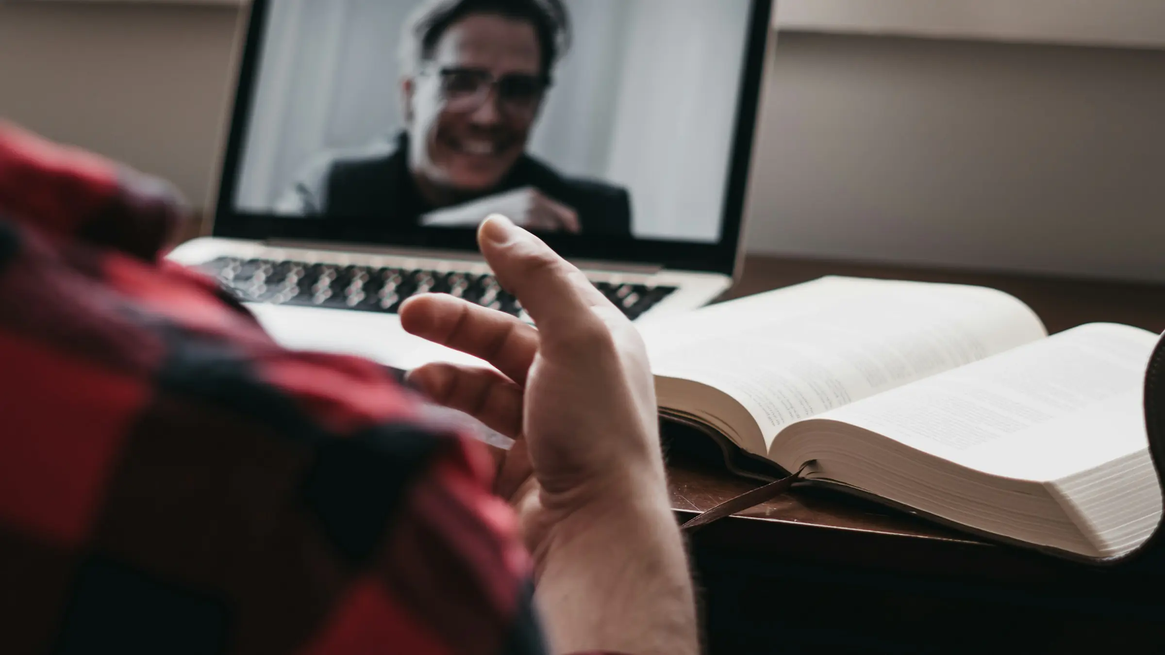 Man on a video call with a remote team from his laptop