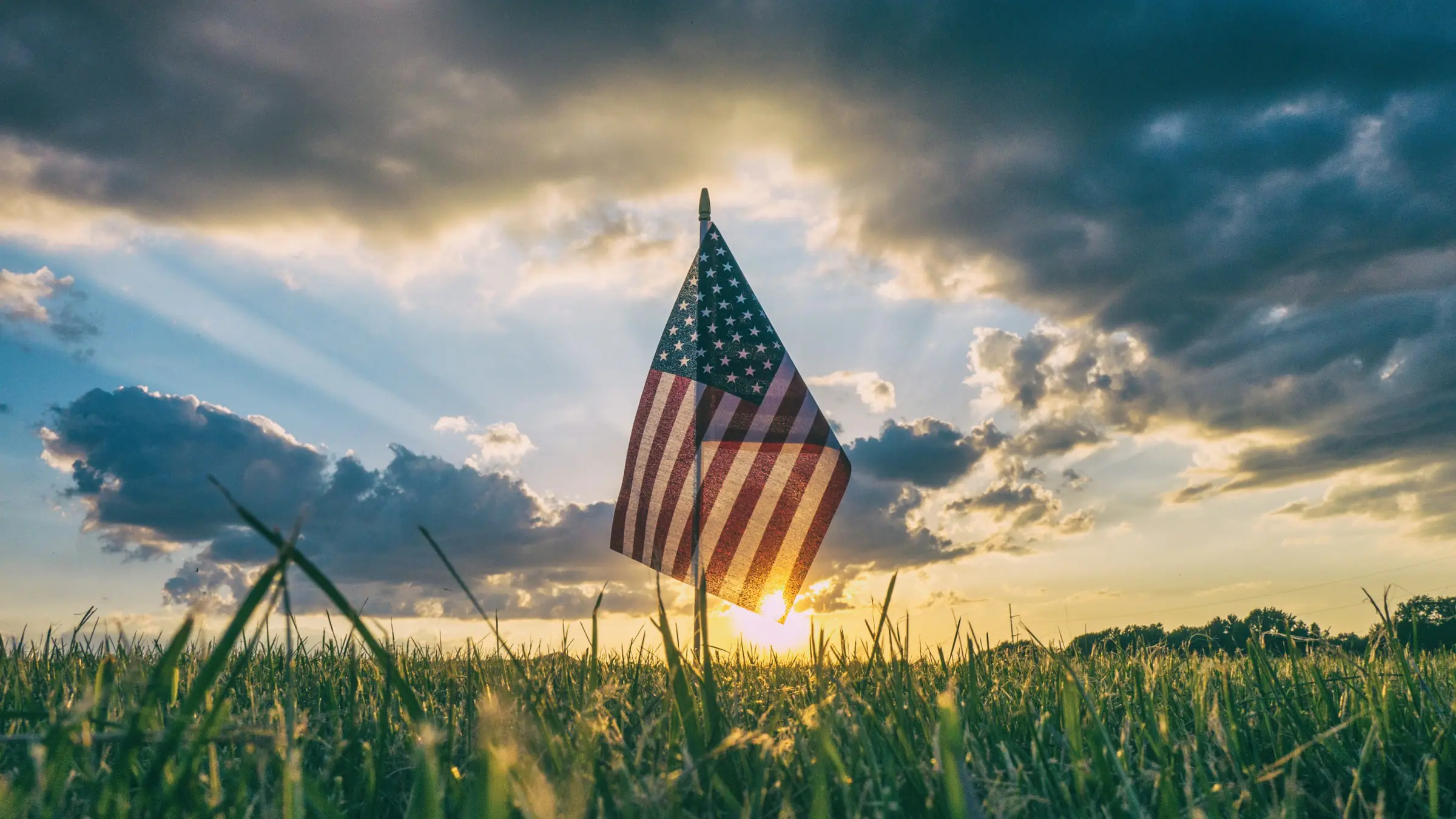 American flag in a field at sunset
