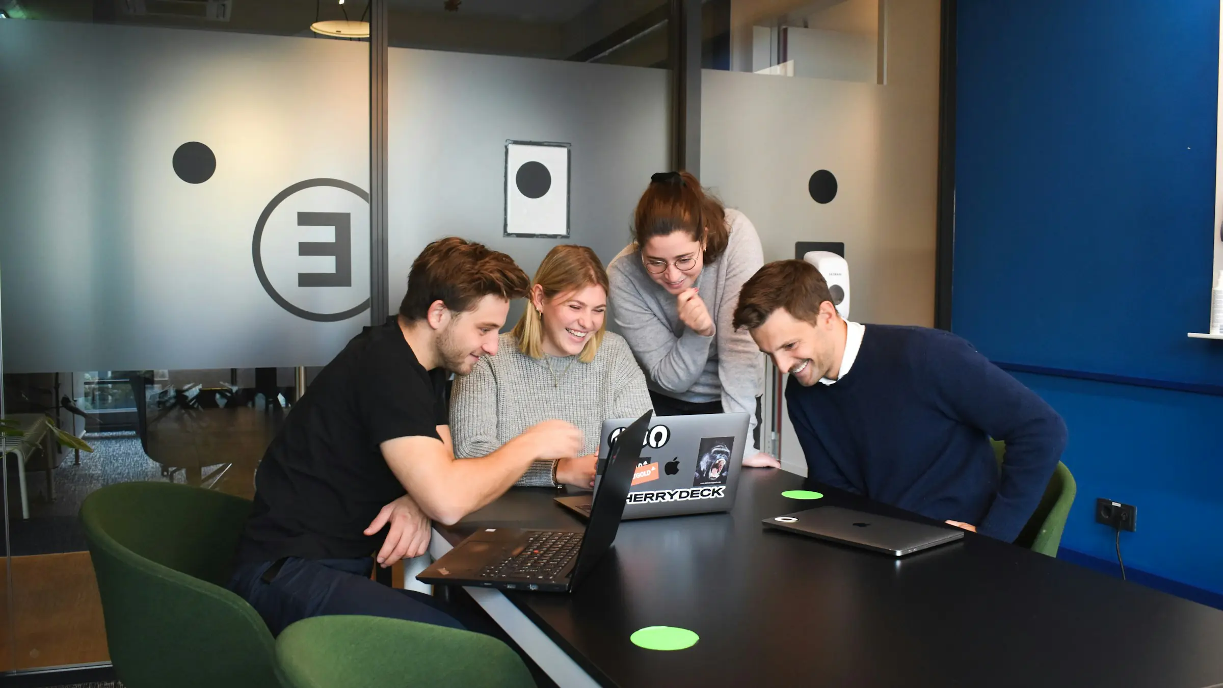 Startup team gathered around a laptop in an office