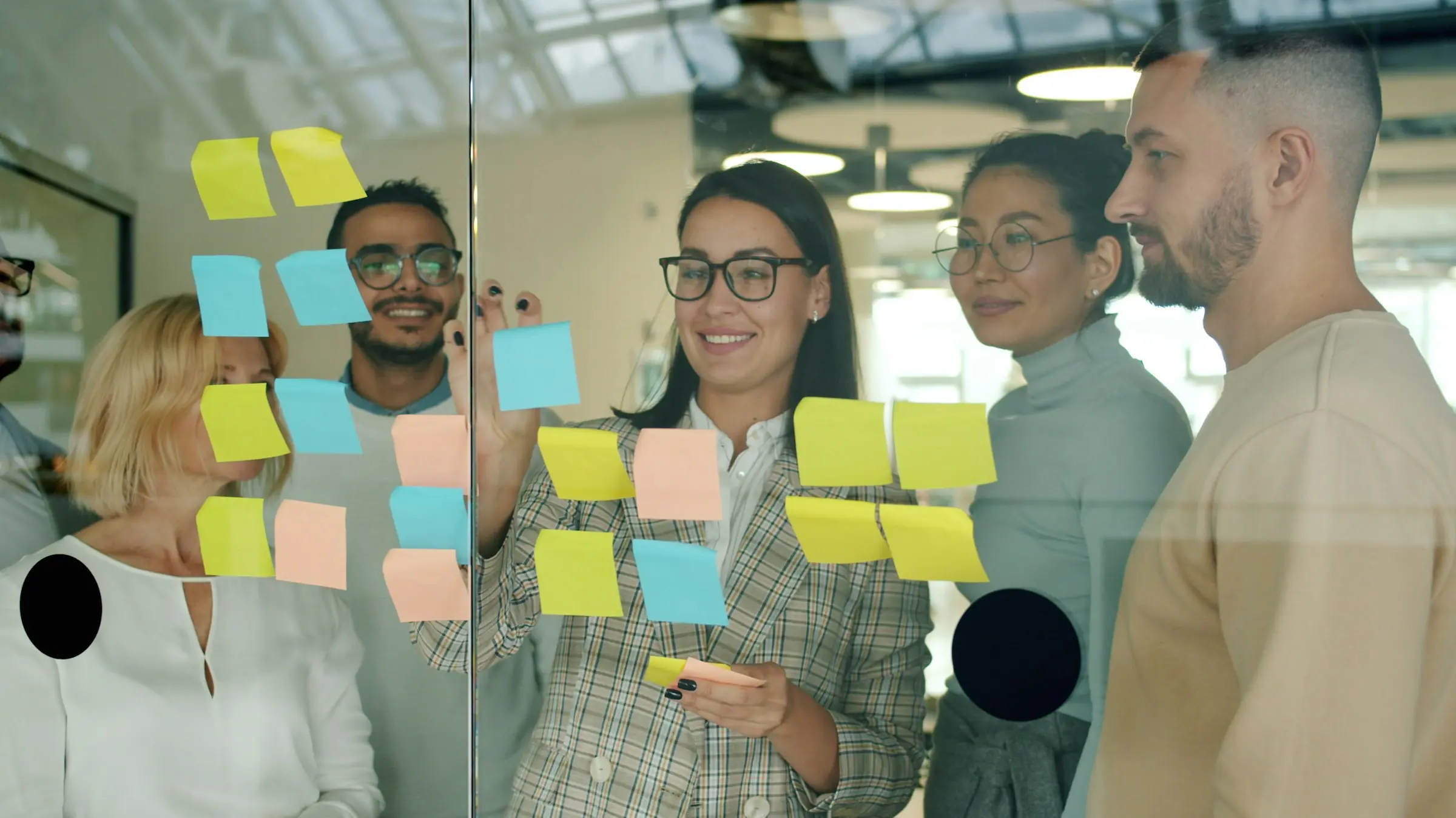 Product team planning with sticky notes on a glass wall