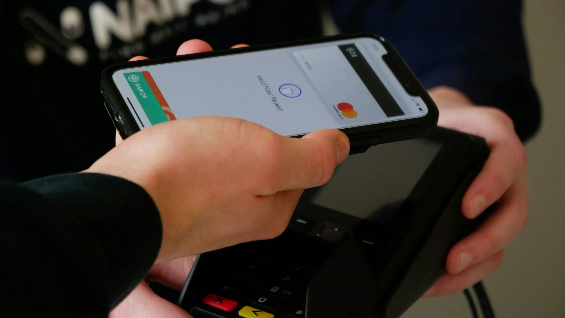 Customer paying with a phone at a card reader