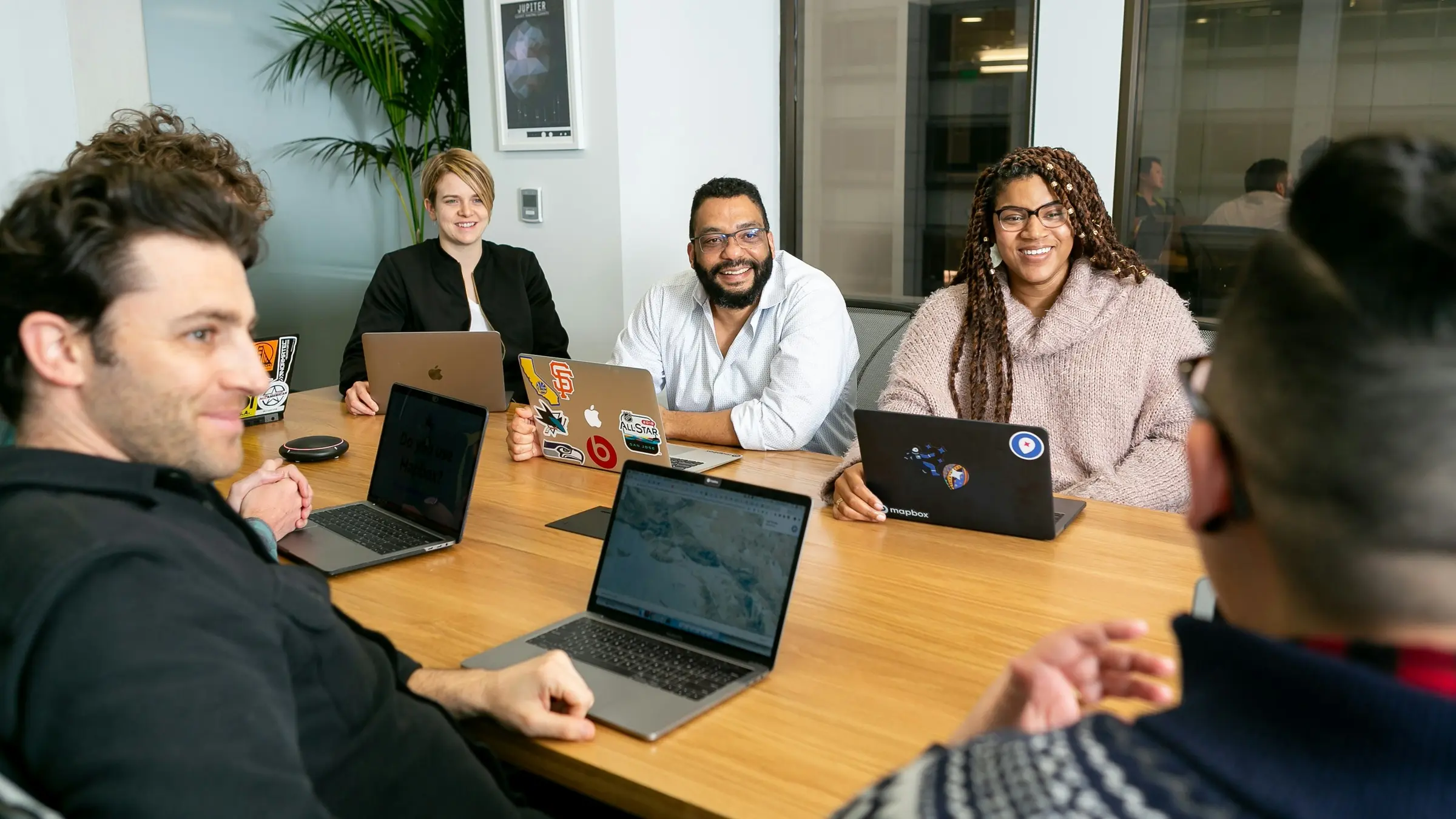 Team meeting around a table with laptops