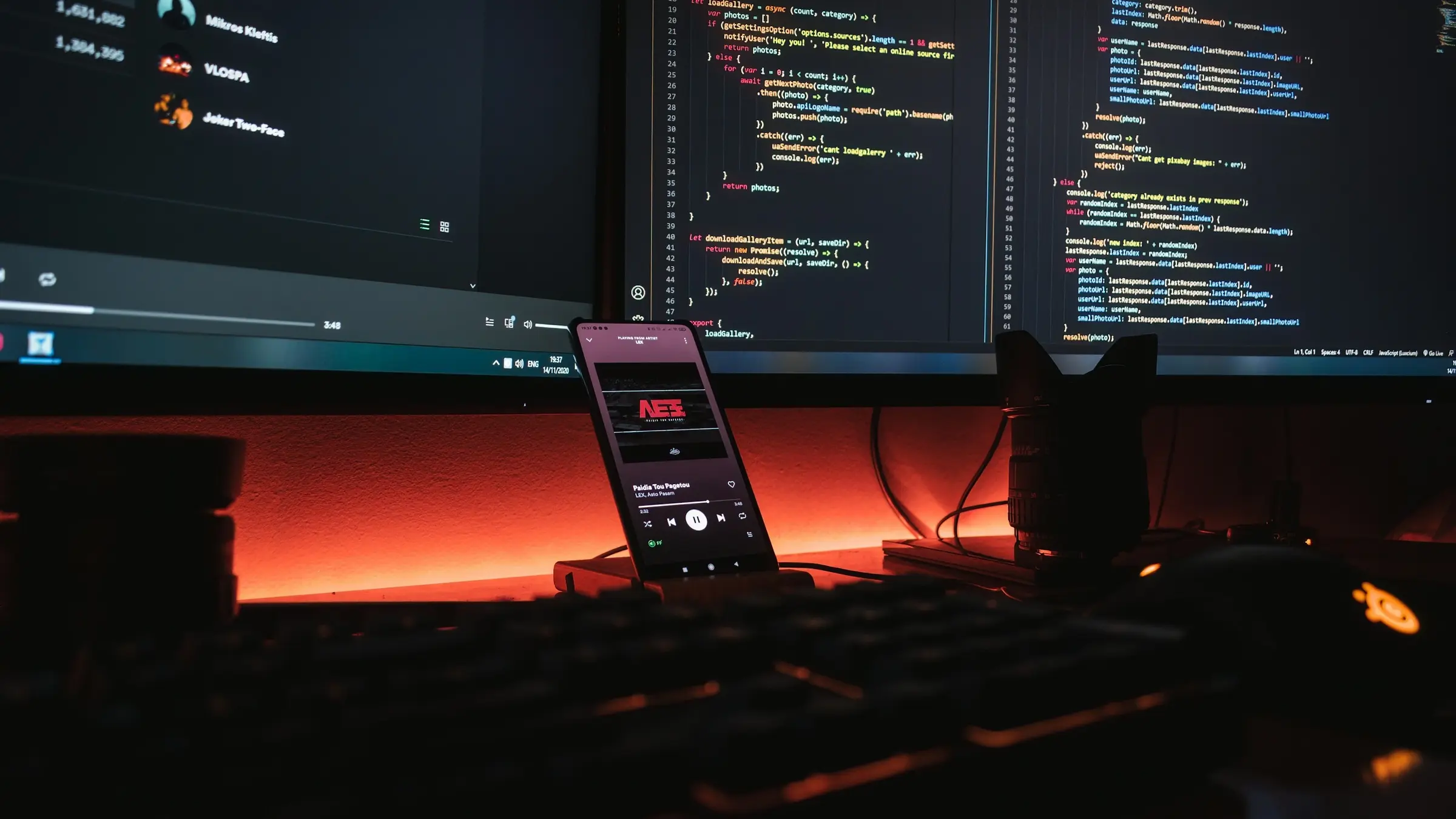 Developer workstation with code on several monitors and a phone