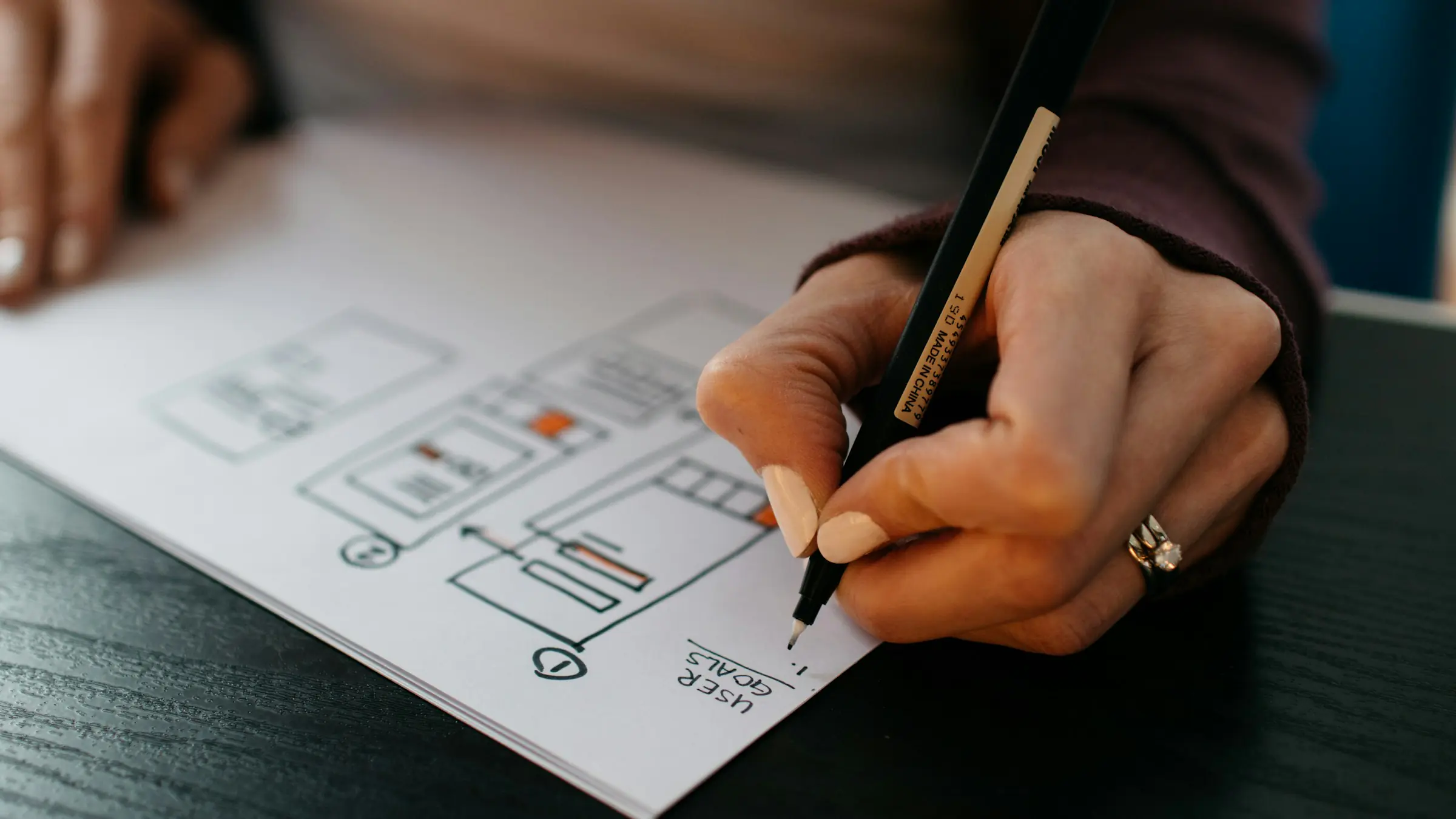 Hand sketching app wireframes on paper