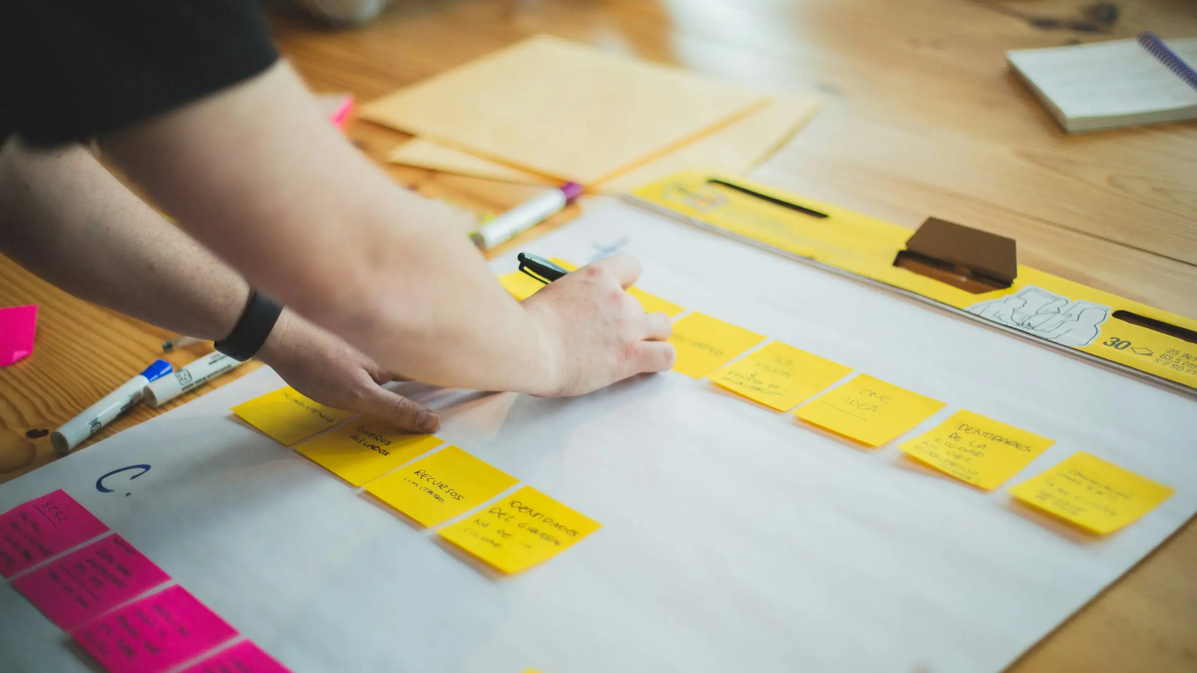 Hands arranging sticky notes during an MVP planning session