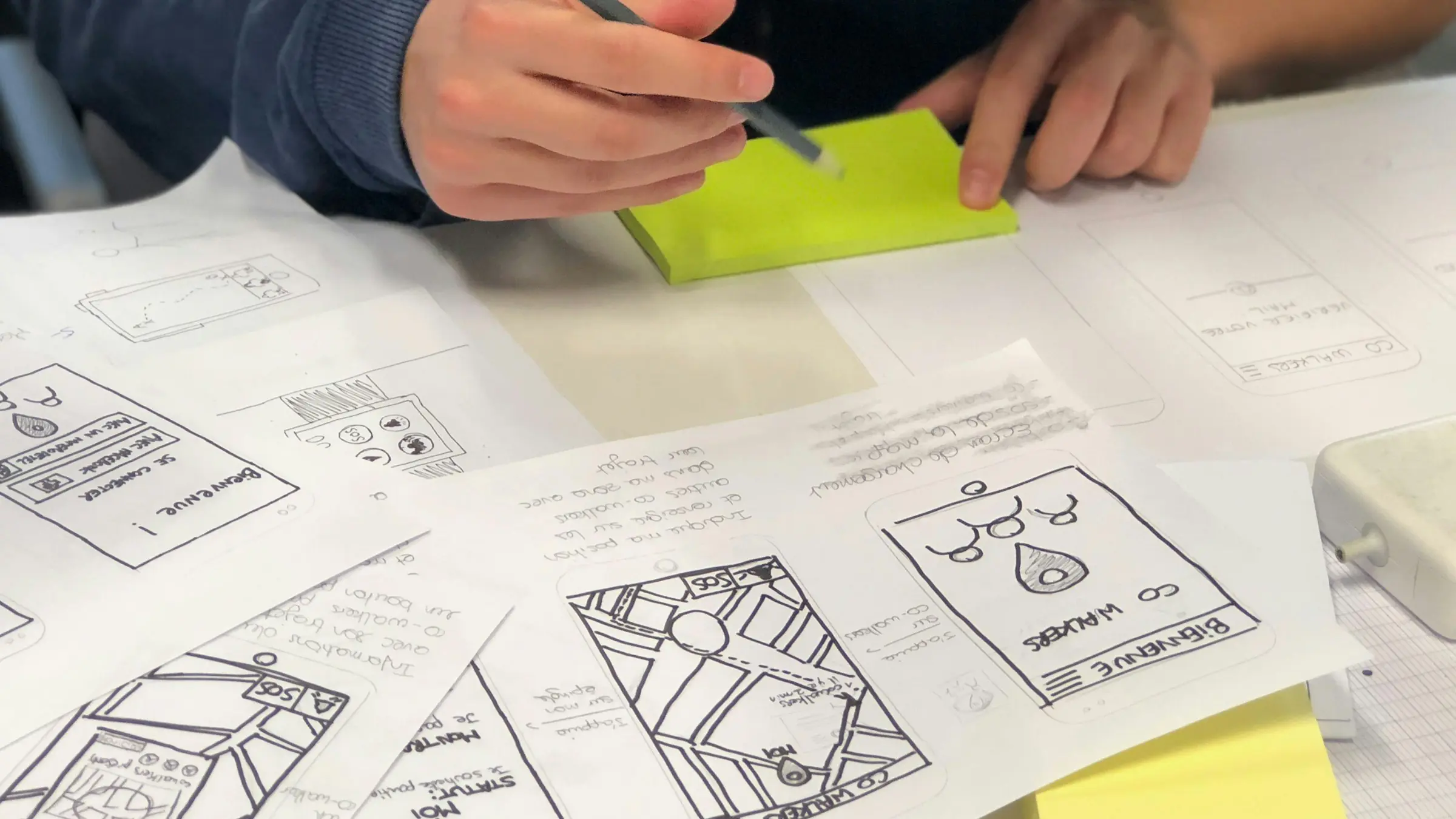 Team sketching paper prototypes and wireframes with sticky notes
